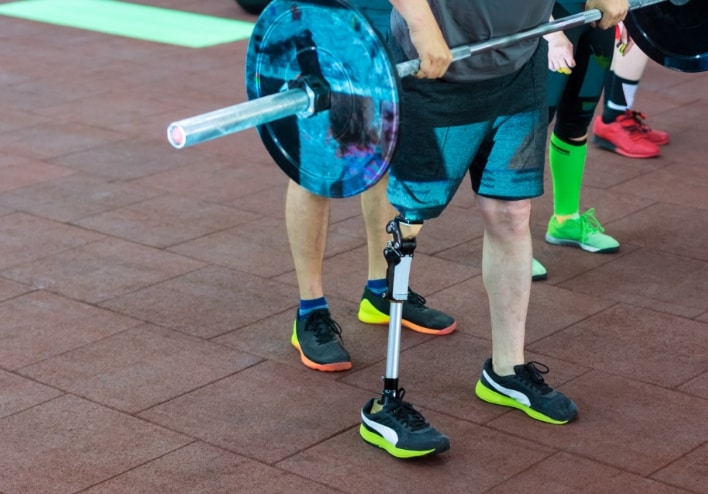 Individual who requires a prosthetic limb performing a deadlift