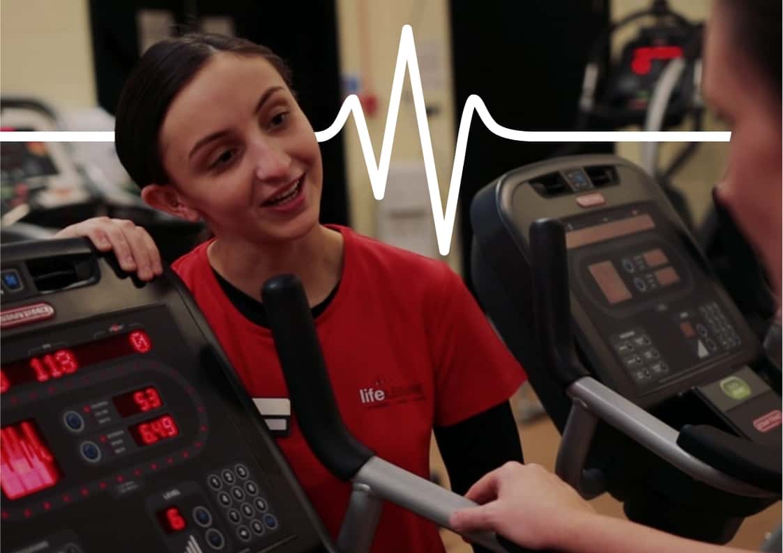 Fitness coach chatting with member using a treadmill